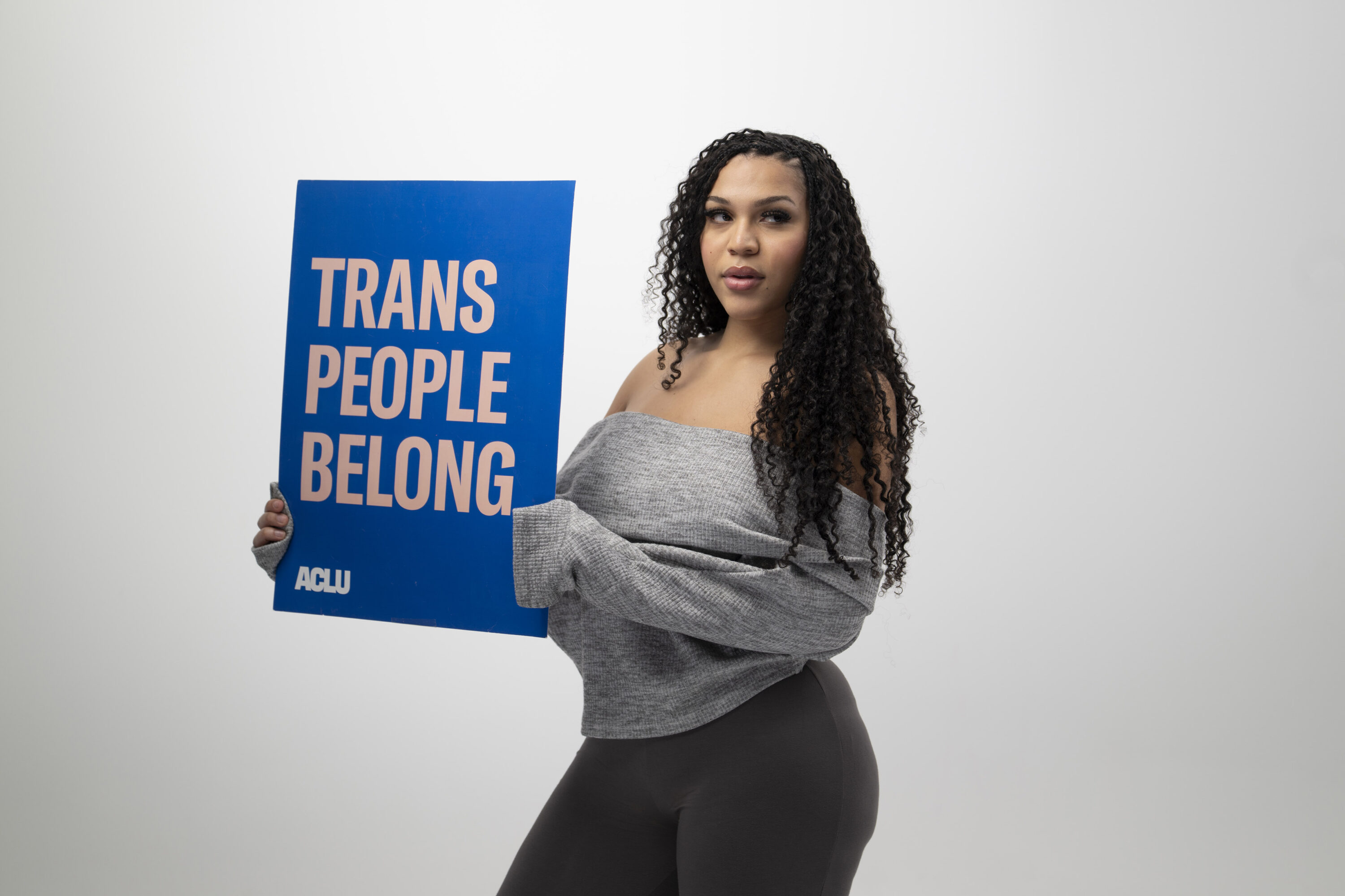 Zaya Perysian holds a sign that reads Trans People Belong
