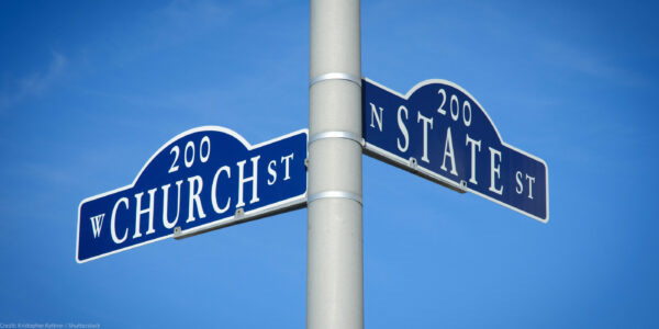 Two street signs at an intersection on a pole reading Church St on one and State St on the other.