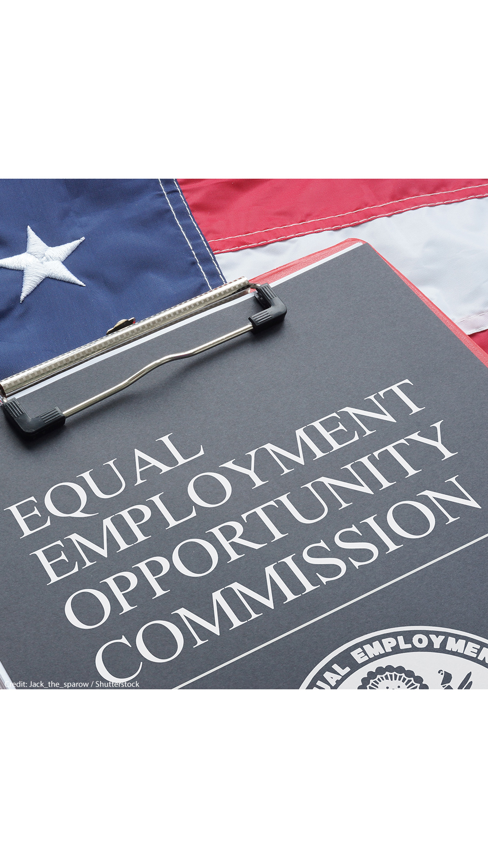 An Equal Employment Opportunity Commission document on a red clipboard that rests on an American flag.