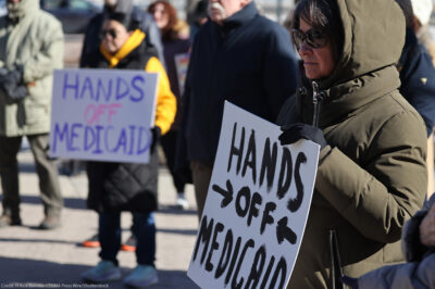 Demonstrators holding signs that read "HANDS OFF MEDICAID" protest the Trump administration's plan to roll back Medicaid expansion during a rally in front of the DuPage County Court House in Illinois.