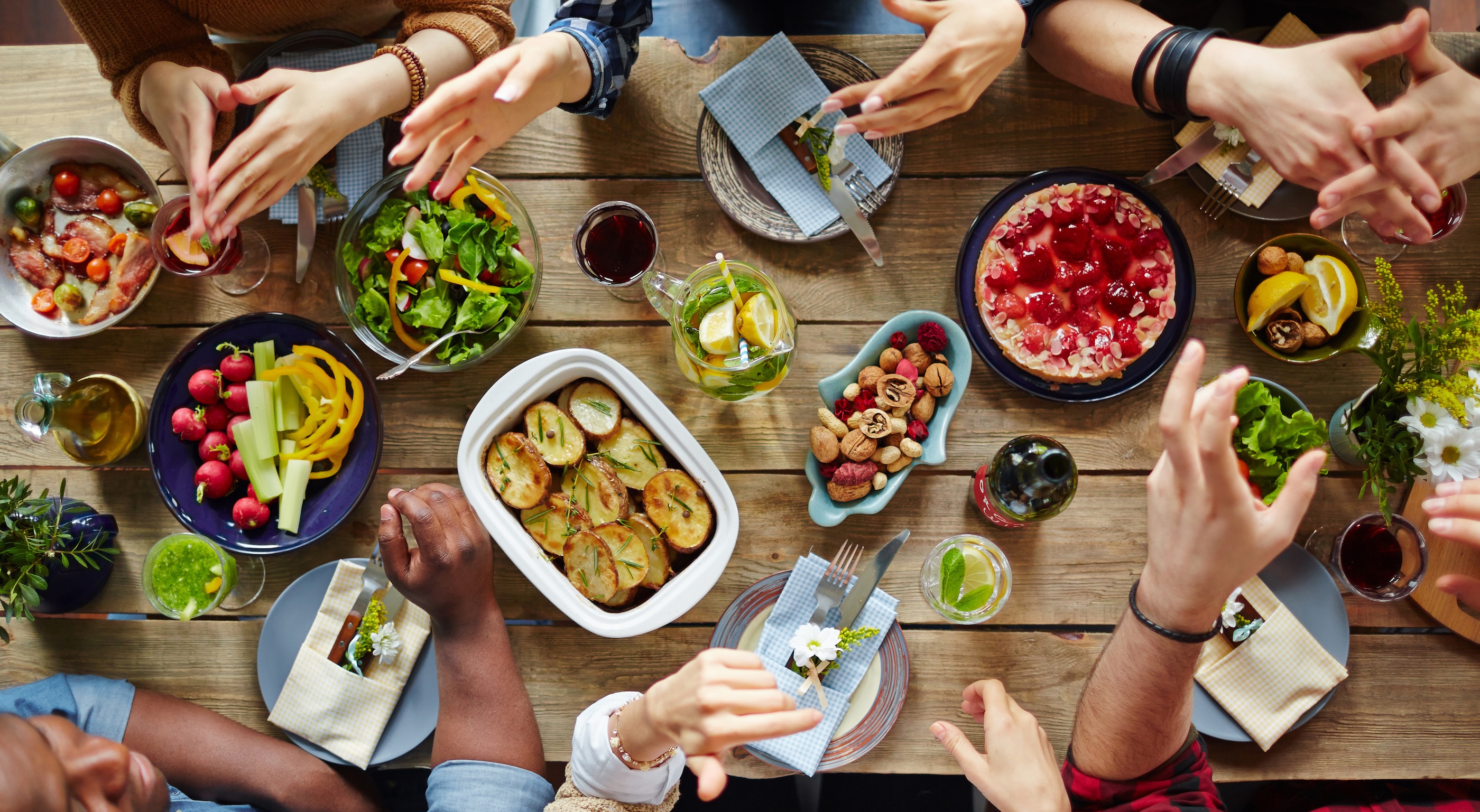 A group of people have an animated conversation over a dinner table.