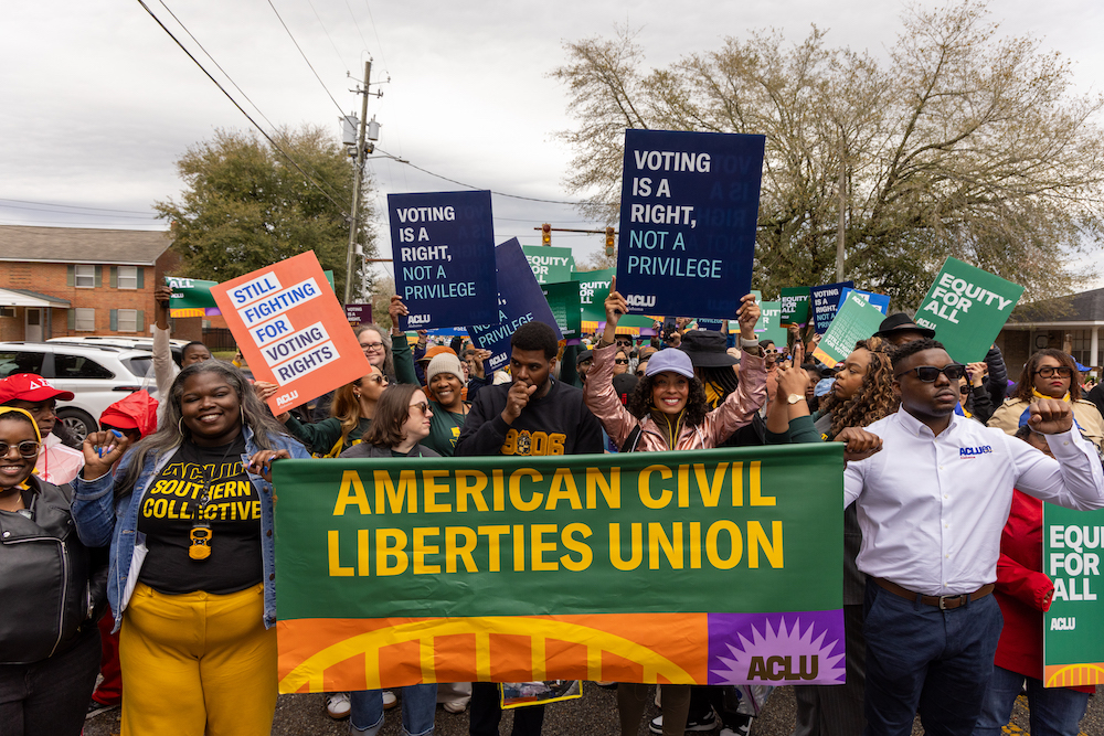 A group of voting rights advocates marching over the Edmund Pettus Bridge.