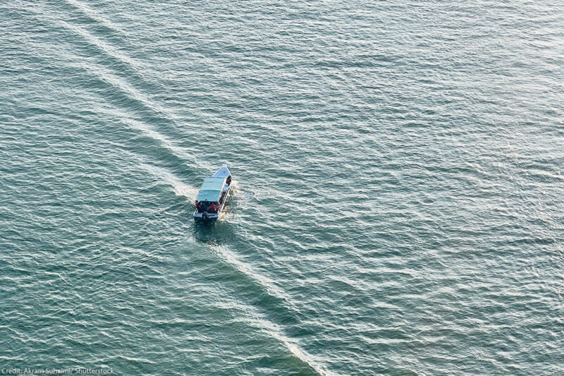 High-angle aerial shot of a small motorboat.