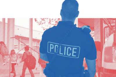 A police officer observing children at a school.